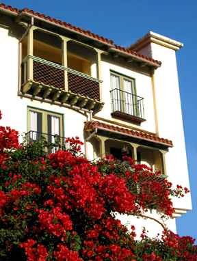 This is a photo of the Topanga Canyon Inn, a bed and breakfast in Topanga, California, built in the style of colonial Mexico with white stucco walls, arched openings, a red tile roof, paving and decorative tile work.